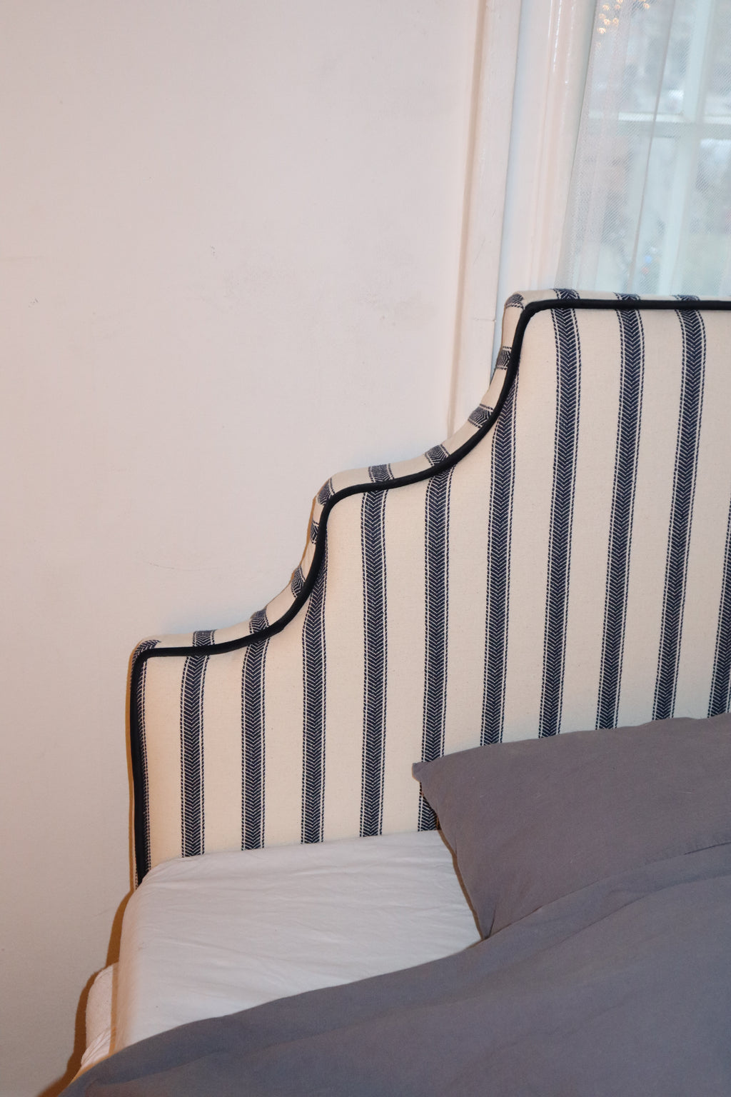 The arch in navy herringbone stripes with black velvet piping.